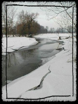 Ein Bach mit dicken, schneebedeckten Eisschichten an den Ufern